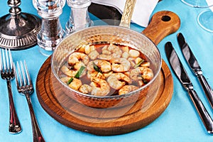 Warm salad of grilled fish pieces, shrimps and mussels in a frying pan, with grilled vegetables