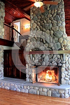 Warm scene in lit stone fireplace showcasing craftsmanship in rustic home