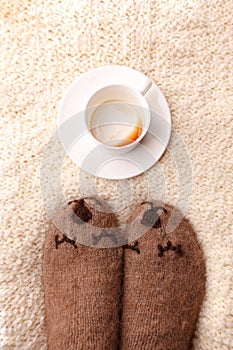 Warm soft blanket, empty cup of espresso coffee, woolen socks. Winter fall autumn cozy still life. Lazy sleepy weekend morning