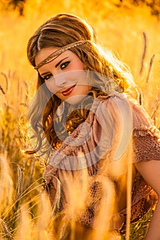 Warm summer haze seventies hippie girl in grainfield.