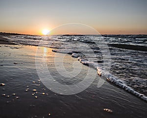 Warm sunset on the Black Sea coast and the mirror surface of the sea on the beach