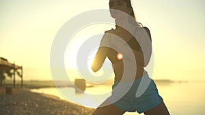 Warm-up on the beach. Sport, yoga, sunrise, slow motion, sea