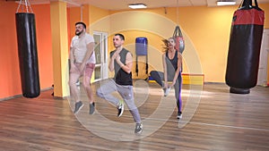 Warm-up at the gym of the coach, a bearded man and girl, starting the training with martial arts, limbering-up, abdomen