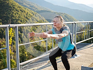 Warm up in the morning in the mountains. Young woman doing exercise,