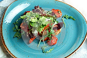 Warm vegetable salad with arugula, pepper, beetroot and tomatoes. Beautiful serving dishes. Light gray background