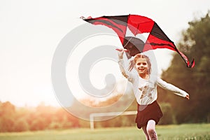 Warm weather. Happy girl in casual clothes running with kite in the field. Beautiful nature