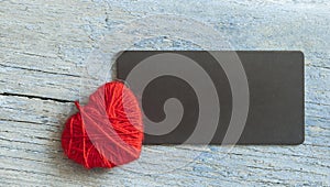 Warm woolen heart, symbol of love, made of red wool yarn threads