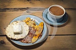 Warmed with beans, egg, arepa, cheese, fried plantain and cup of hot chocolate - traditional Colombian breakfast photo