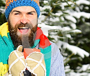 Warming drinks concept. Guy with firtrees covered with snow photo
