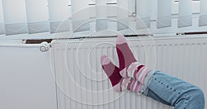 Warming frozen feet on a hot panel radiator in winter.