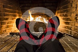 Warming her feet in a fireplace