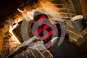 Warming her feet in a fireplace