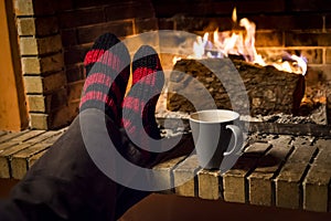 Warming her feet in a fireplace