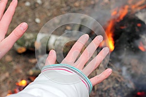 Warming his hands near the fire