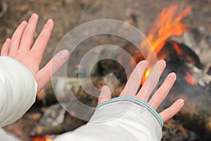 Warming his hands near the fire