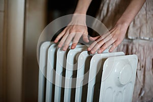 Warming his hands over a radiator.Warm battery.