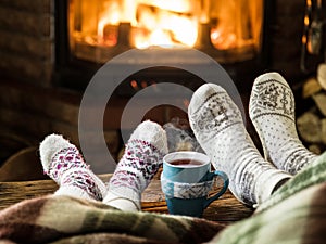 Warming and relaxing near fireplace with a cup of hot drink.