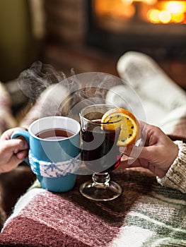 Warming and relaxing near fireplace with a cup of hot drink.