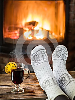 Warming and relaxing near fireplace with a cup of hot wine.