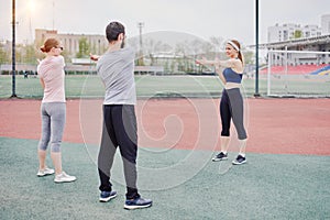 Warming up exercises with a trainer outdoors