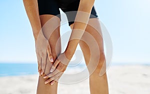 Warming up to avoid sports injuries. a sporty young woman suffering from a sports injury.