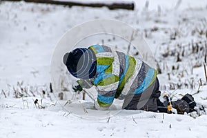 Warmly dressed boy playing with snow