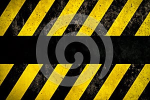 Warning background with yellow and dark stripes painted over concrete wall facade texture and empty space for text message in the