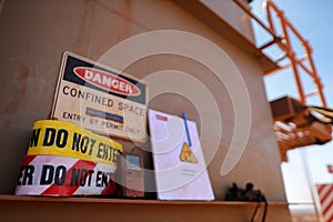 Warning barricade danger tape, caution tape with defocused gas leak test atmosphere detector at confined space permit