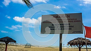 The warning board for the tourist that come to the Batu Burok Beach to swim at their own risk