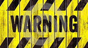 Warning danger sign word text as stencil with yellow and black stripes painted on wood wall plank texture wide panorama background