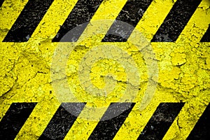 Warning danger sign yellow and black stripes pattern with yellow area over concrete cement wall facade peeling cracked Danger sign