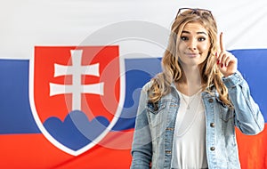 Warning finger up by blonde girl standing in front of flag of Slovakia