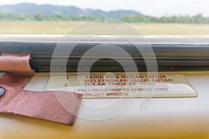 Warning or instruction sign on the window of a helicopter in both Malay and English language heading to offshore Terengganu