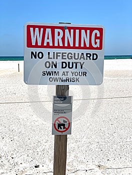 Warning No Lifeguard on Duty. Swim At Your Own Risk Sign.