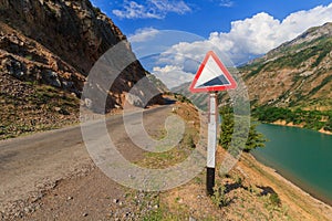 Warning road sign. The landscape of Uzbekistan. Uzbekistan, western Tien-Shan mountains.