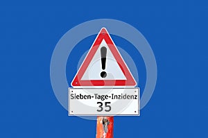 Warning seven day incidence 35 sign on blue background in german photo