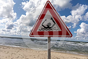 Warning sign alerting swimmers of the potential risks of swimming in the ocean