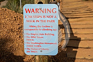 Warning sign at the base of the Manitou Incline hike in Colorado, reminding hikers that this is a difficult hike up the stairs