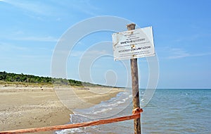 Warning Sign on the beach of the nature reserve at the mouth of the river Bevano