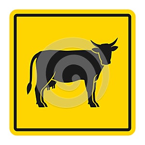 Warning sign for cattle on the road. Silhouette of cow on yellow background