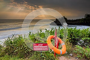 Warning Sign at a cliff and ray of lights at pura batu bolong, b