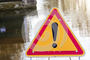 warning sign of danger in front of a flooded road