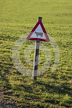 A warning sign with a designed black cow