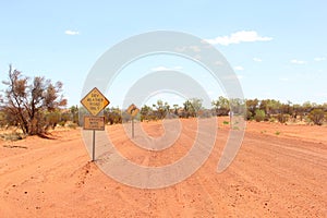 Warning sign for dry weather road only, unsealed traveling in the Australian Outback