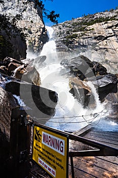 Warning sign due to Wapama Falls flowing over the footbridge and creating hazardous conditions for crossing; Hetch Hetchy