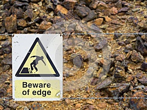 Warning sign at the edge of unstable cliff