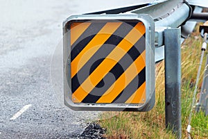 Warning sign at the end of a road guardrail