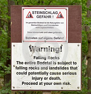 Warning sign of falling rocks and landslides at the entrance of the Bodetal near Thale, Harz. German text identical to English te