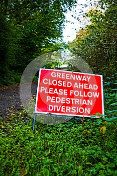 warning sign that the footpath is closed ahead pedestrians to follow a diversion photo