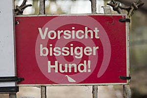 Warning sign on a gate to warn in the german language for a biting dog who guards the premisis